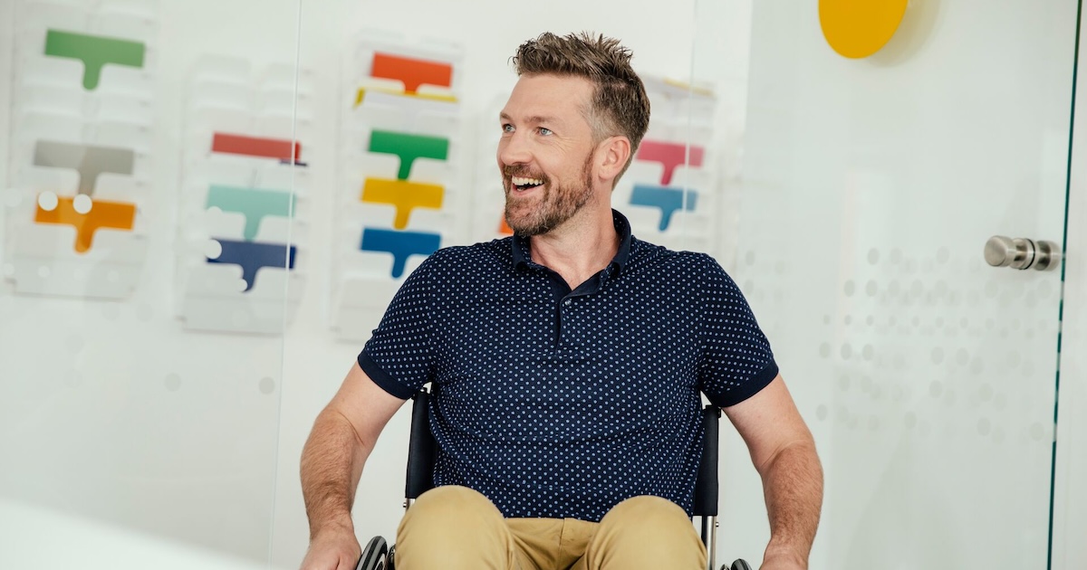 A smiling person in a wheelchair