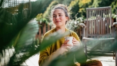 Person sitting outside while drinking a cup of coffee