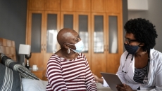 Doctor in mask talking to patient in mask