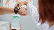 A doctor helping set up a patient's smartwatch.