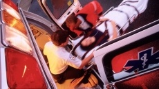A paramedic pushing a gurney out of an ambulance.