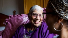 An older woman sitting with a younger woman at home.