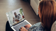 A person talking to a provider through a video chat on a laptop