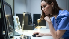 Healthcare provider sitting at a desk while looking at a computer