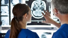 Two healthcare providers looking at a brain scan