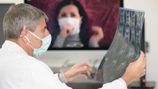 A physician looking at an x-ray image while in video consultation