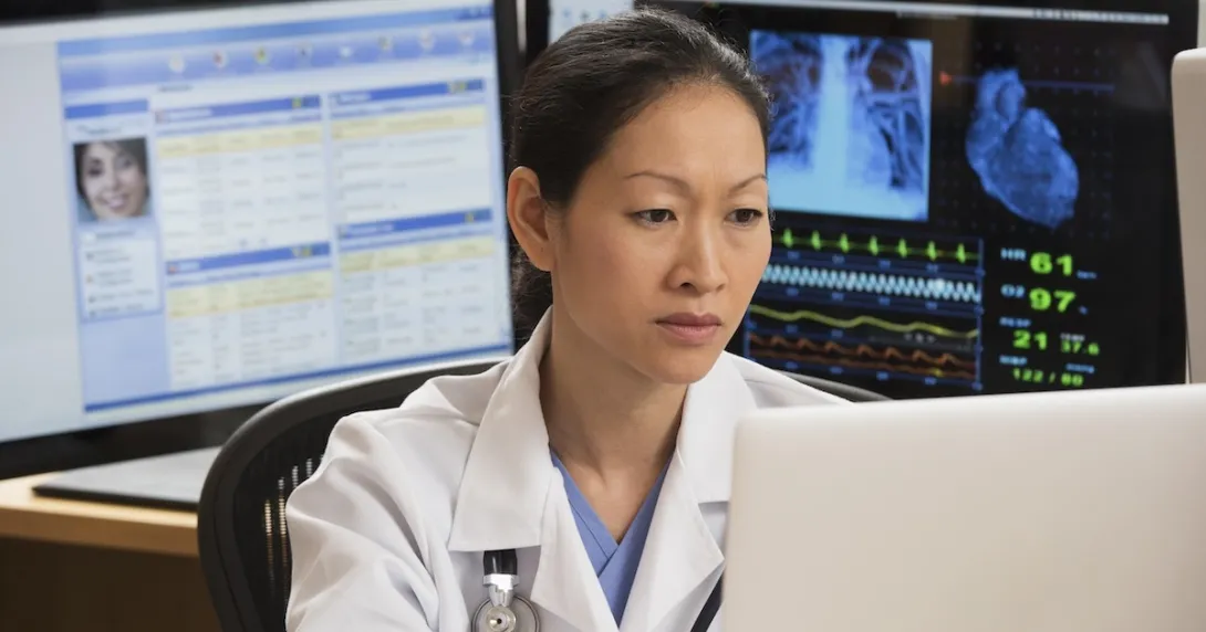 Healthcare professional reviewing patient data on a PC