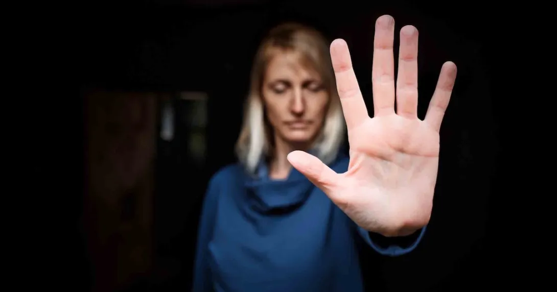 Person showing stop sign with hand