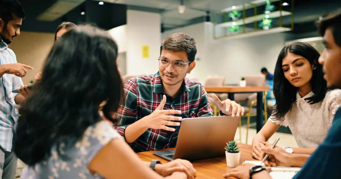 Group of individuals sitting around a table talking