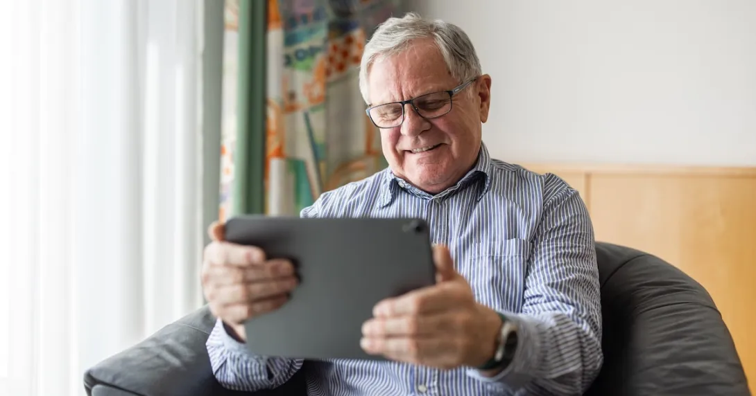 Person sitting in a chair while looking at a tablet