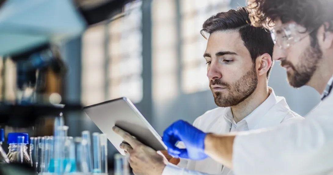 Two researchers in a laboratory using a digital tablet