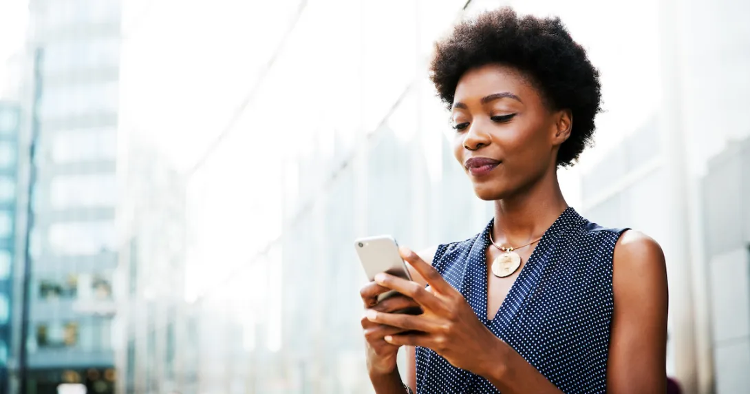 Women standing on a street looking at her phone
