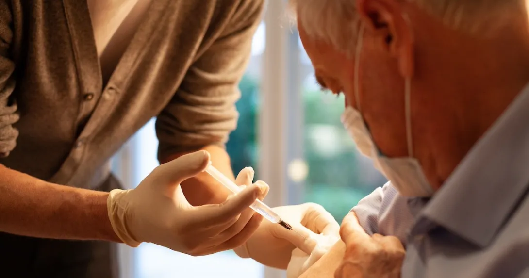 Healthcare practitioners administering injection to patient