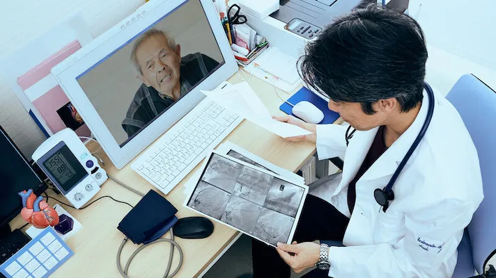 Doctor doing telehealth while looking at x-ray scans