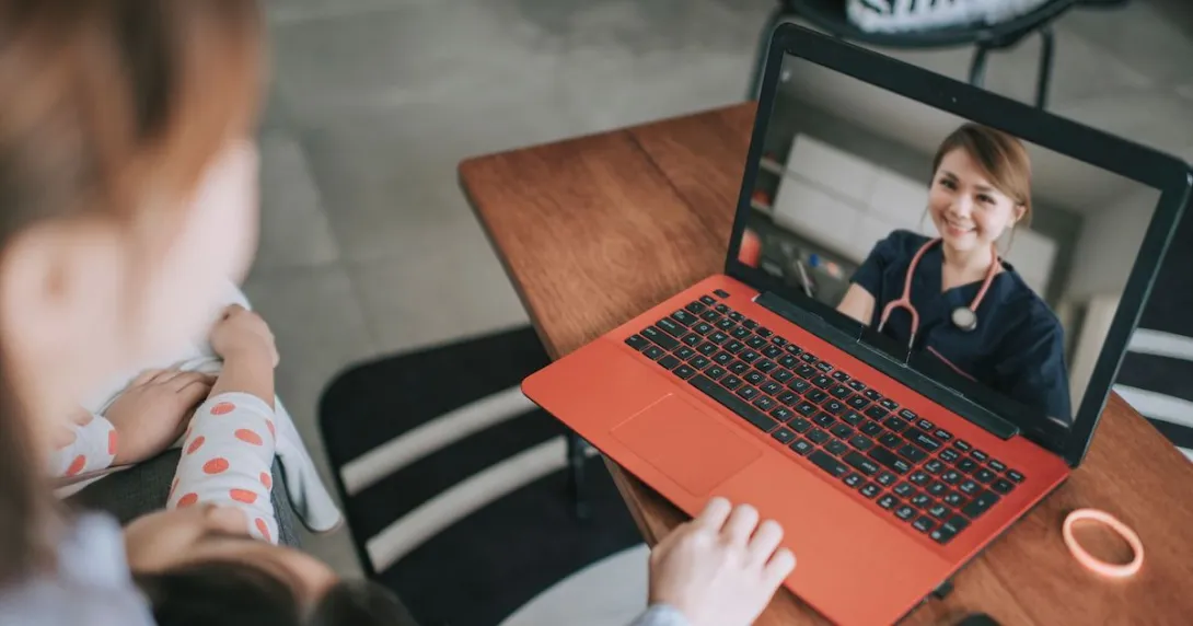 A woman talking to a provider via her laptop