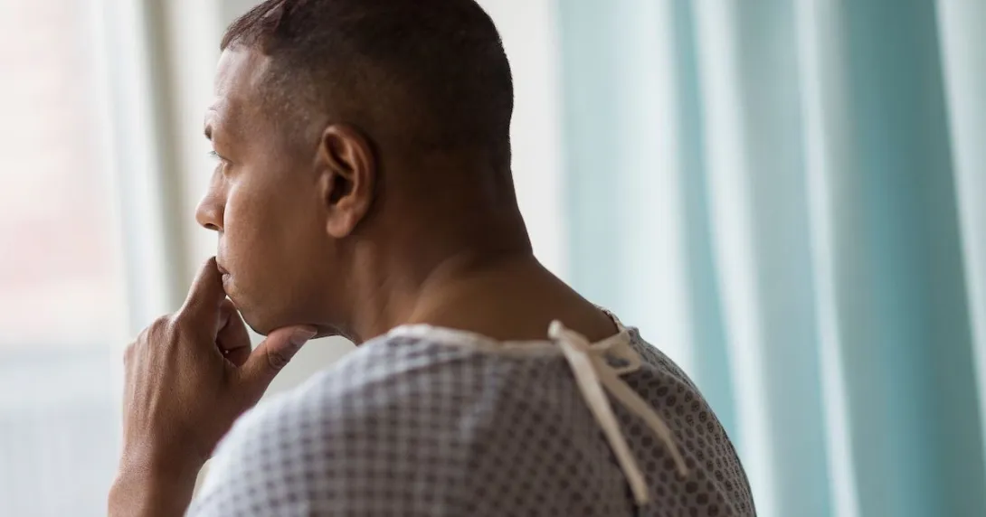 Person standing by a window looking out