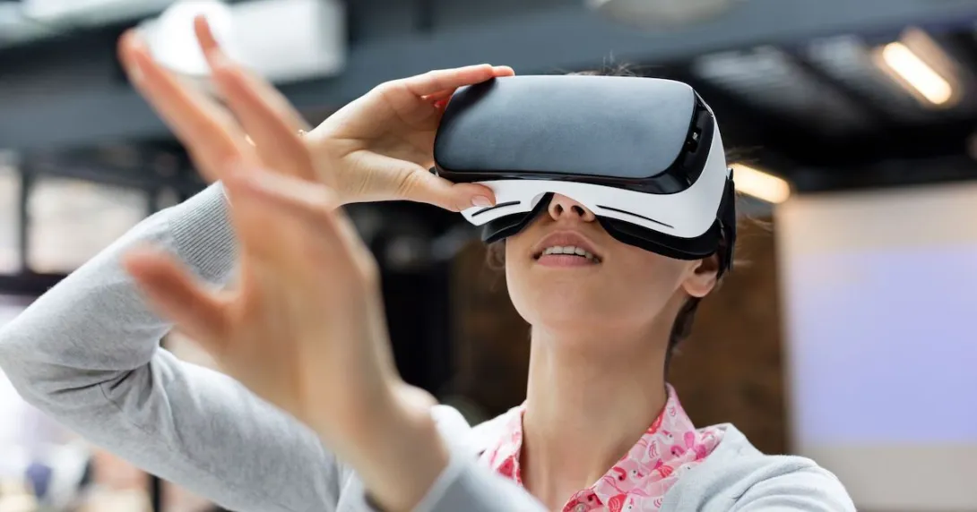 Person wearing a virtual reality headset with their hand extended toward the camera