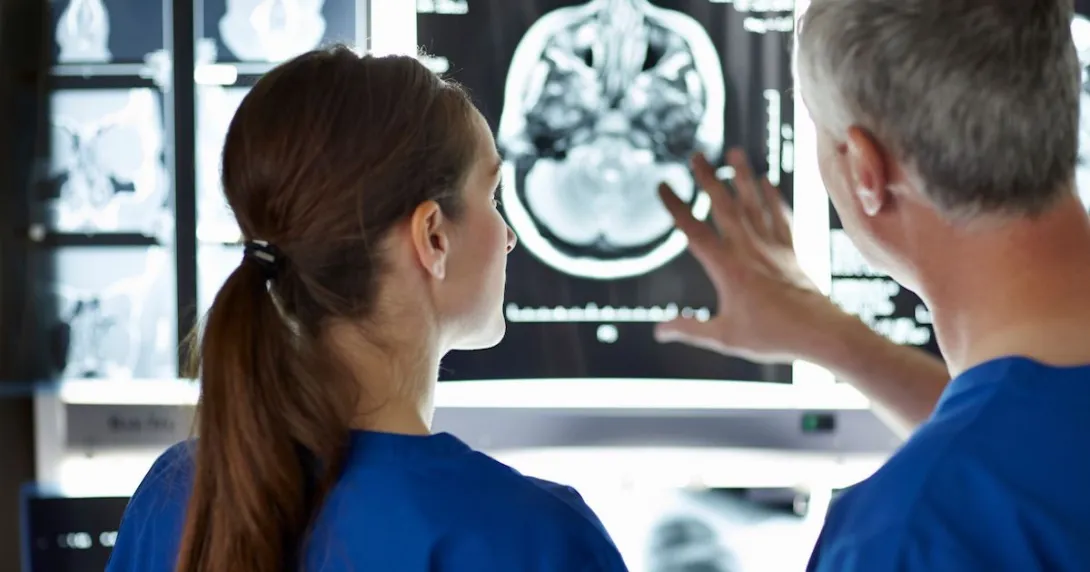 Two healthcare providers looking at a brain scan
