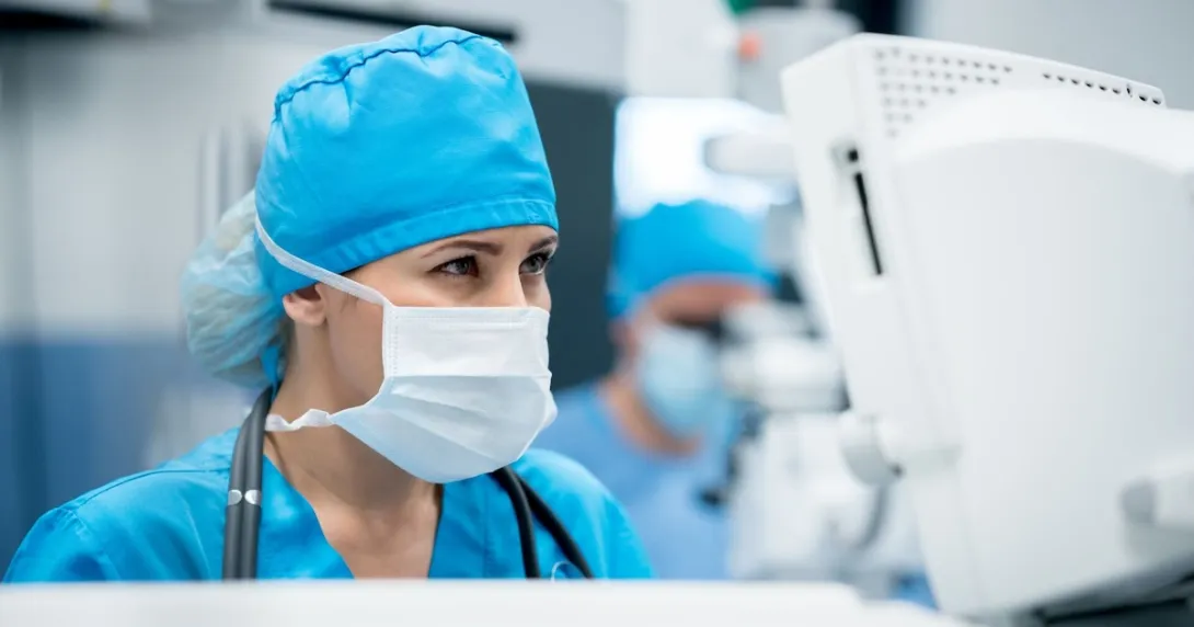 Surgeon in an operating room looking at a computer screen