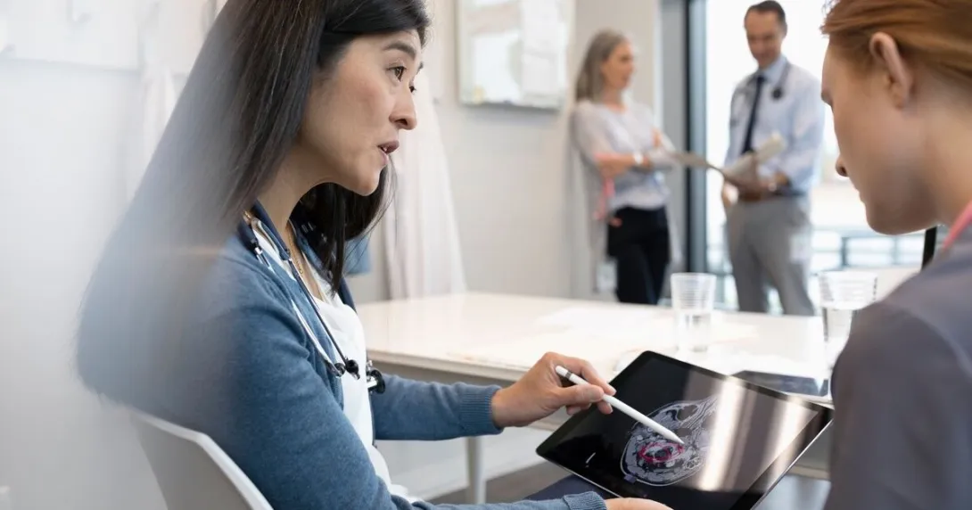 A physician showing a patient their brain scan through a mobile tablet